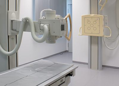 Raum, in dem ein digitales Röntgengerät steht mit Liegebank und Röntgenkopf